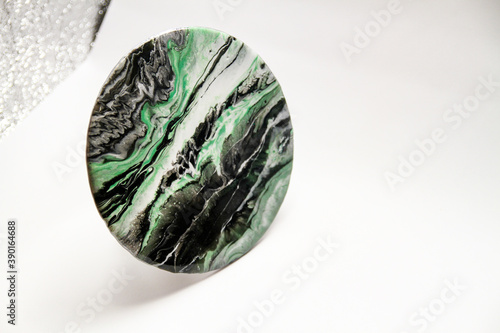Close-up view of green, white and black epoxy resin marbles in circular piece