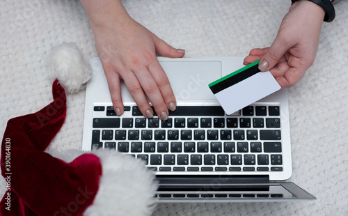 A woman orders gifts over the Internet. A woman's hand holds a credit card. Online ordering. Online shopping