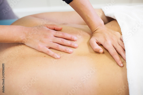 close up Female physiotherapist giving back massage to male patient