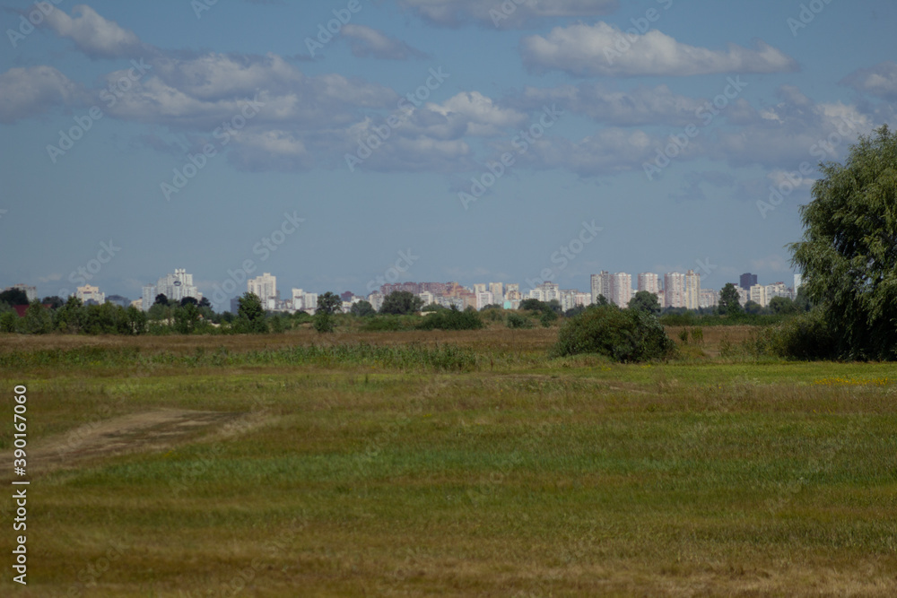 Obraz premium landscape with trees and clouds and the city in the background 