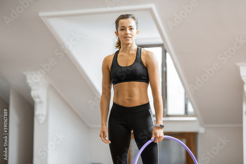 Portrait of an athletic woman practising rhythmic gymnastics with a hoop in the gym © rh2010