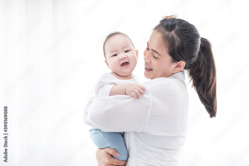 Asian woman smile and holding son baby in her arms. Happy family. Asia mother lifting and looking her adorable kid baby on white. love people concept