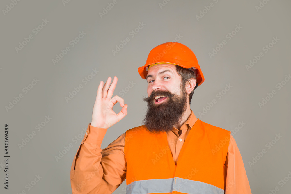 Bearded man in protective helmet shows sign ok. Man in hard hat. Construction worker in hardhat. Business, industry, technology. Builder concept. Bearded man in protective helmet shows sign ok. Man in hard hat. Construction worker in hardhat. Business, industry, technology. Builder concept.