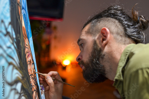 Male artist painting with artificial light