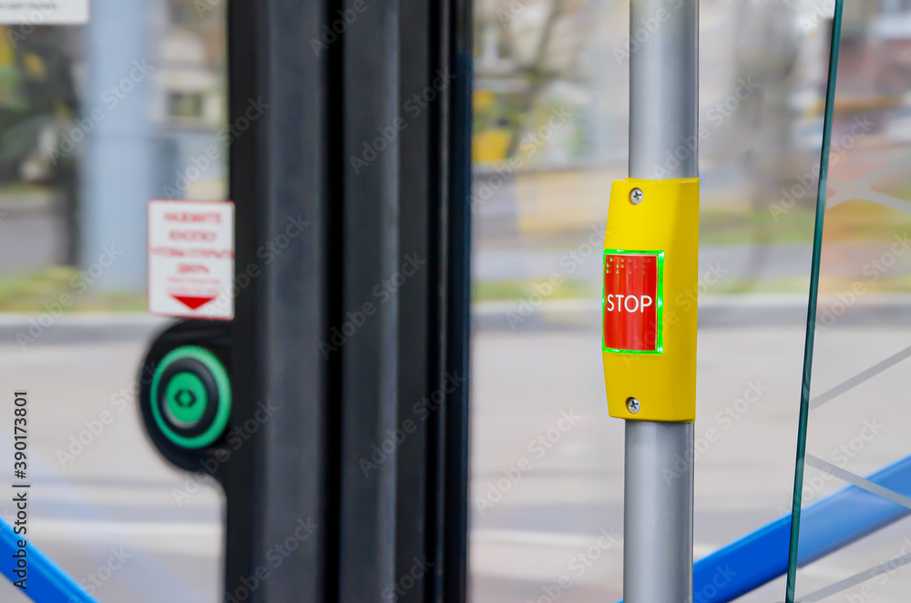 Emergency stop or demand stop button on vertical handrail in passenger compartment. Details in cabin of public passenger transport. Selective focus Emergency stop or demand stop button on vertical handrail in passenger compartment. Details in cabin of public passenger transport. Selective focus