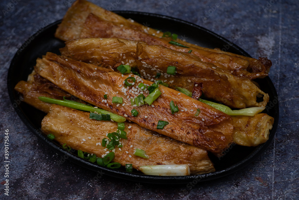 Teriyaki yuba tofu skins ribs on dark plate Teriyaki yuba tofu skins ribs on dark plate
