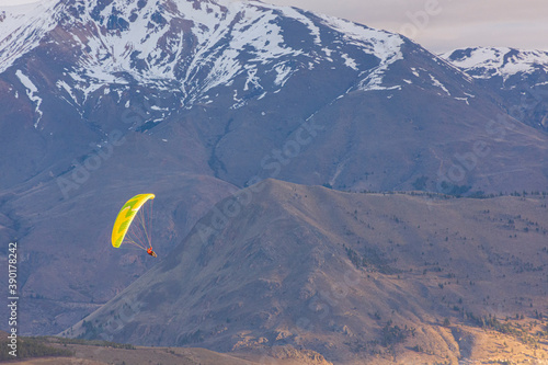 Paragliding against snow-capped Andes mountains during winter season in Esquel, Patagonia, Argentina