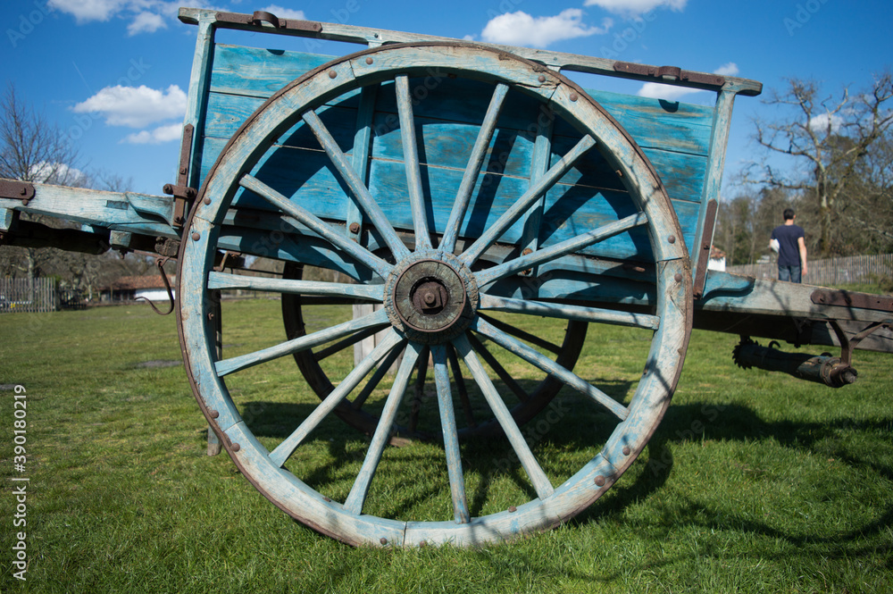 Une roue d'une vieille charrette bleue dans un champ