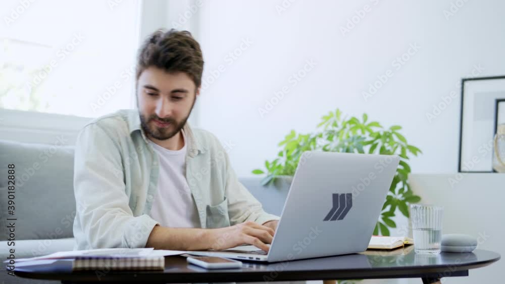 Young man working from home typing on laptop Young man working from home typing on laptop