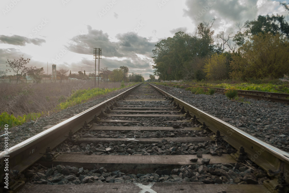 View of train rails under cloudy sky