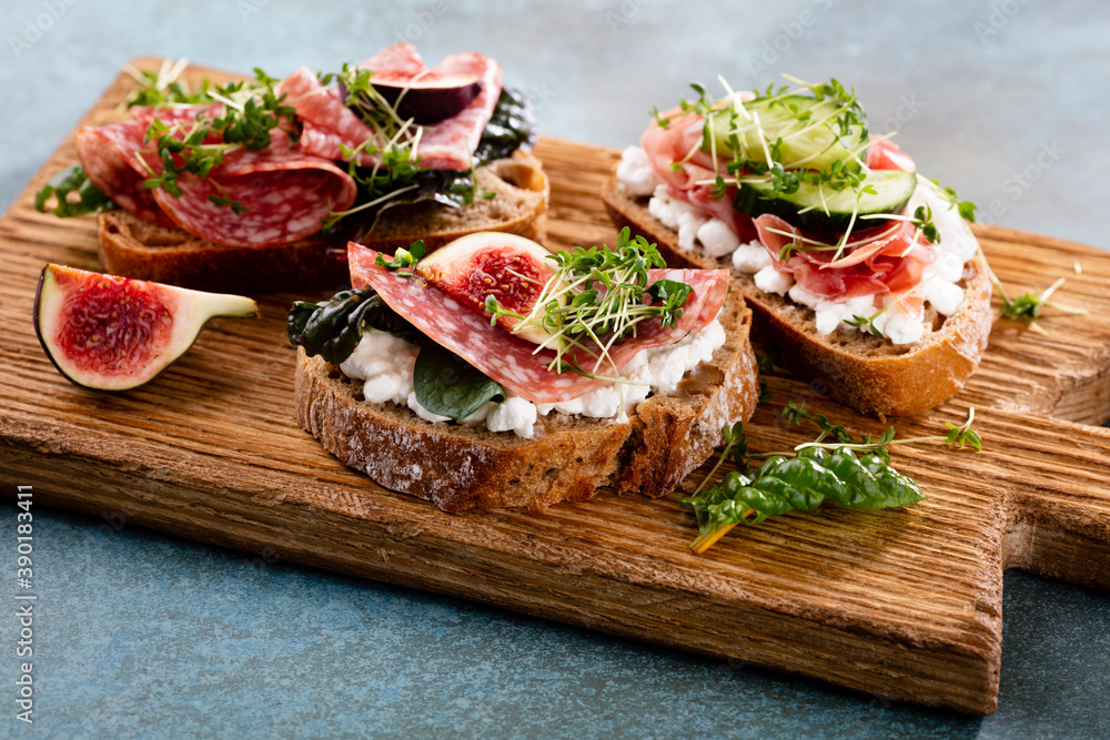 Variety of mini sandwiches with cream cheese, vegetables and salami. Variety of mini sandwiches with cream cheese, vegetables and salami.