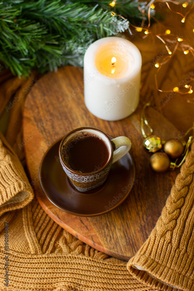 a cup of coffee and a candle on a chalkboard on a cozy warm sweater and a sprig of a Christmas tree a cup of coffee and a candle on a chalkboard on a cozy warm sweater and a sprig of a Christmas tree