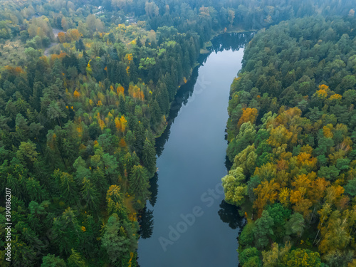 view from the bird's eye view of the beautiful river and colorful autumn forest on a cloudy day, the photo with the drone.