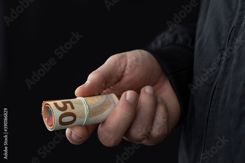 Photos Close up of male hand offering cash on black background