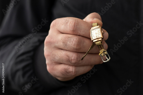 Canvas-taulu Male hand holding an old gold wristwatch