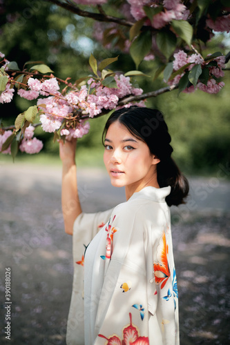Portrait of woman holding branch of tree