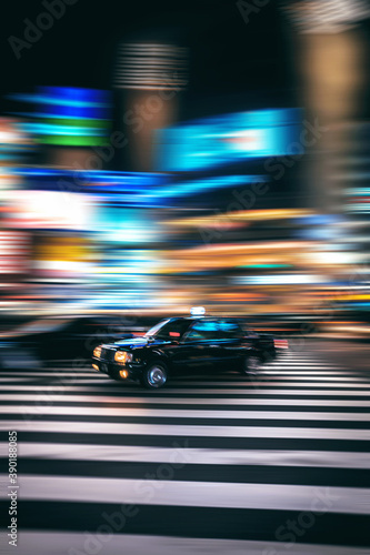 Blurred motion of taxi driving on city street at night