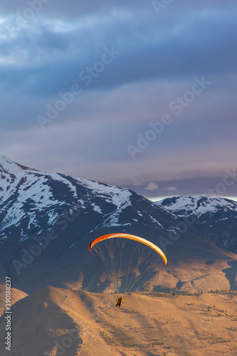 Paragliding against snow-capped Andes mountains during winter season in Esquel, Patagonia, Argentina