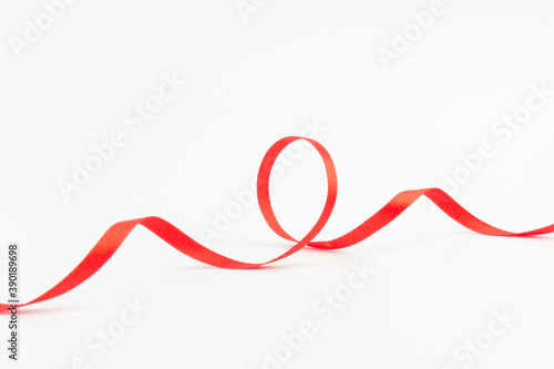 Top view of Red ribbon isolated shiny rolled on white background. Flat lay view.