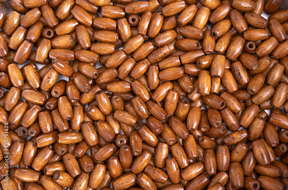 Fototapeta premium Top view of wooden beads background, closeup. Selected focus.