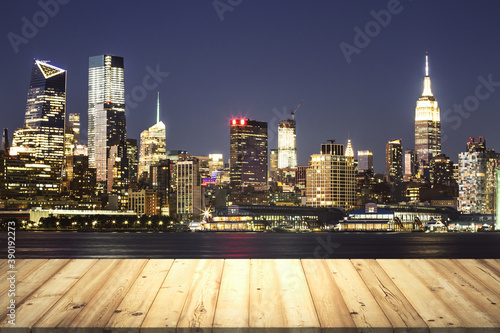 Wooden table top with beautiful New York skyline at night on background, mockup