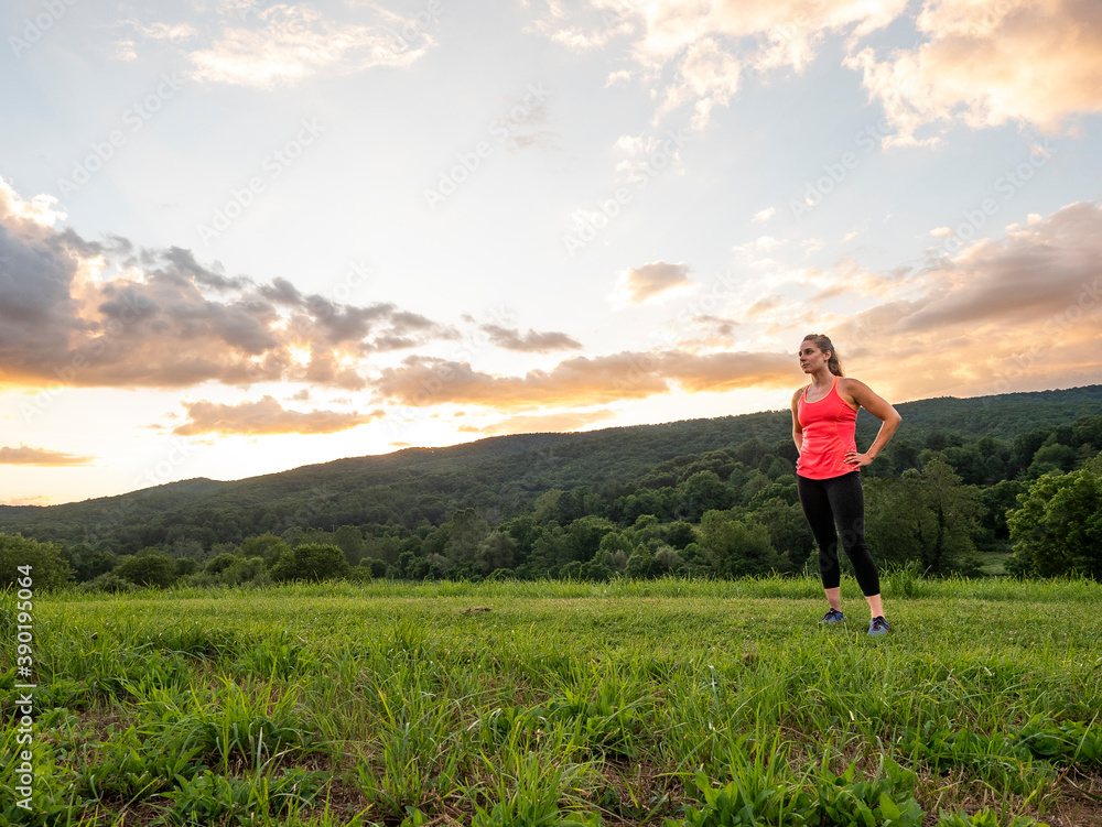 USA, Woman in running outfit standing in field USA, Woman in running outfit standing in field