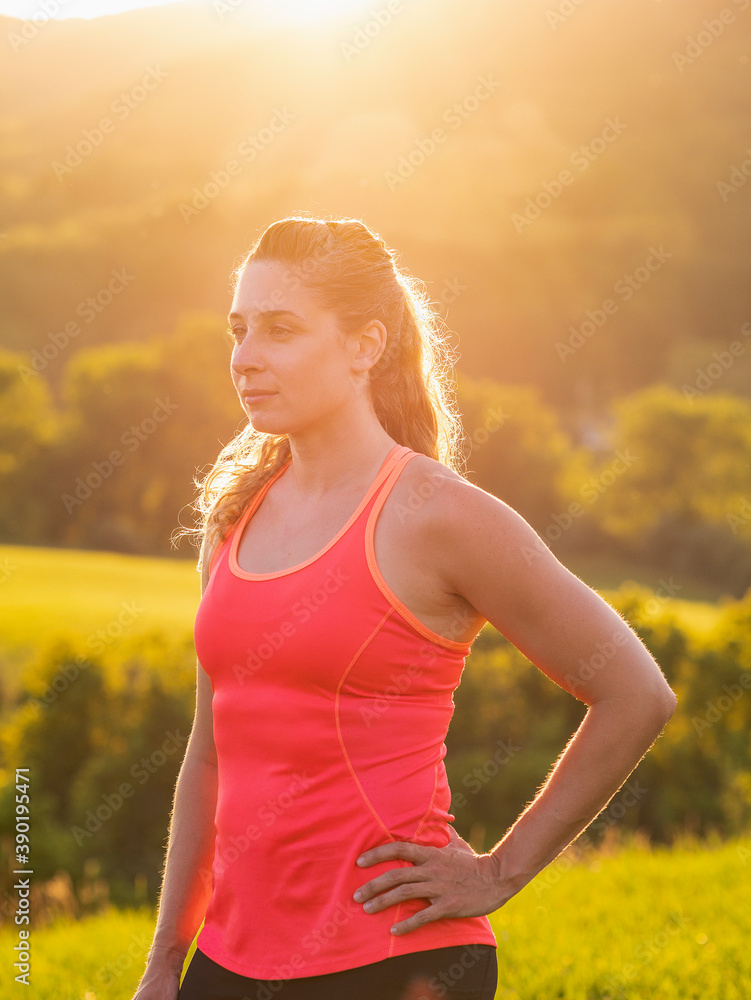 USA, Woman in running outfit standing in field USA, Woman in running outfit standing in field