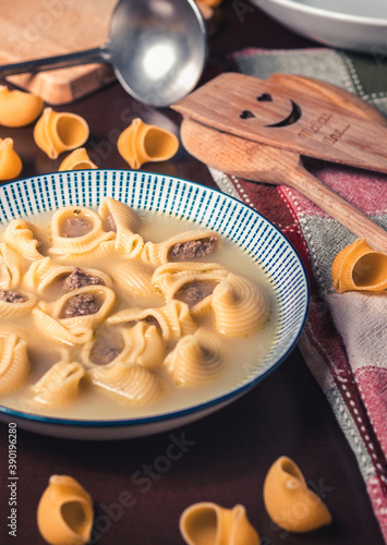 Sopa de galets rellenos de carne picada con galets crudos de decoración y utensilios de cocina