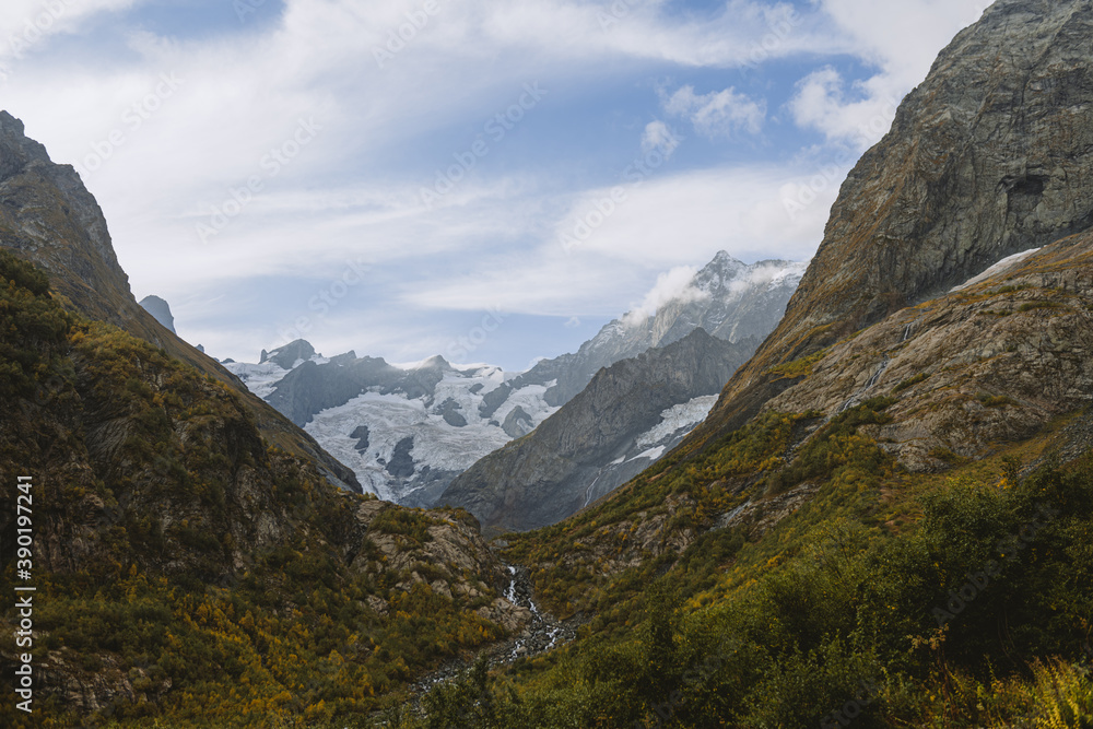 River canyon in mountains. Valley of river and glacier. Beautiful background of Caucasus mountains.
