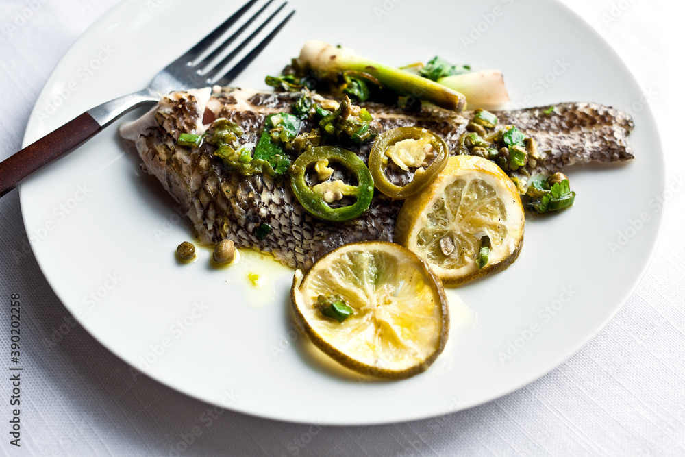Close up of roasted fish with lime salsa verde served on plate Close up of roasted fish with lime salsa verde served on plate