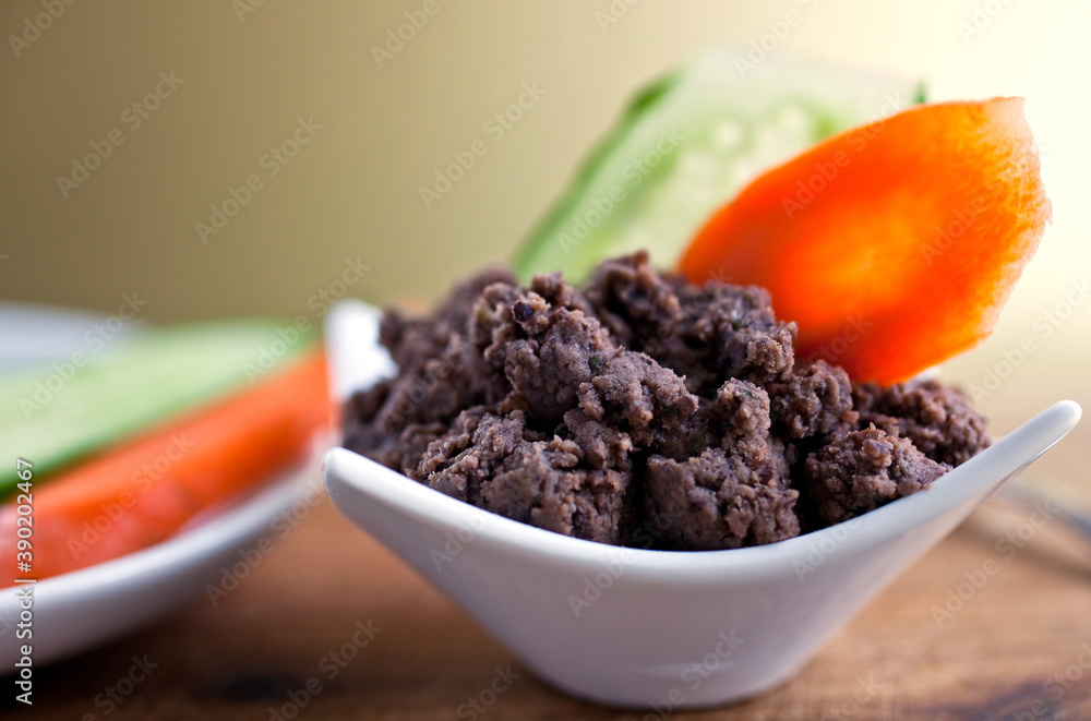 Close up of black bean pate garnish with carrot slice on table Close up of black bean pate garnish with carrot slice on table