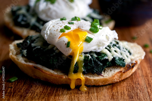 Close up of beet greens bruschetta with poached egg and fontina served on table photo