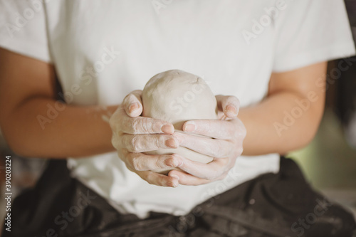 Closeup of woman hands holding piece of clay.