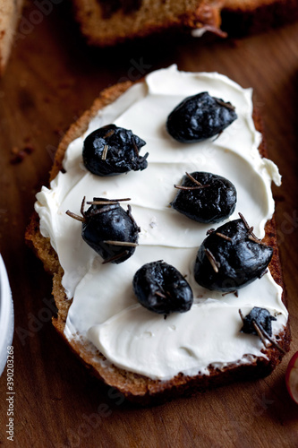 Close up of whole wheat date bread slice with black olives and cream cheese