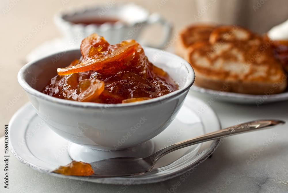 Close up of meyer lemon blood orange marmalade served with crumpet and tea Close up of meyer lemon blood orange marmalade served with crumpet and tea