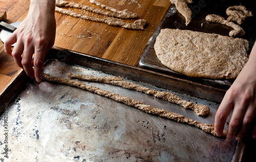 High angle view of man preparing whole wheat sesame breadsticks