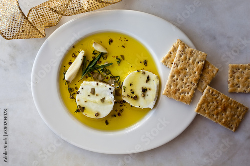 Close up of marinated goat cheese served with crackers