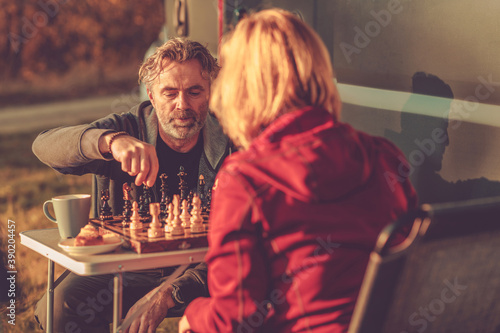 Friends Playing Chess Next to Camper Van