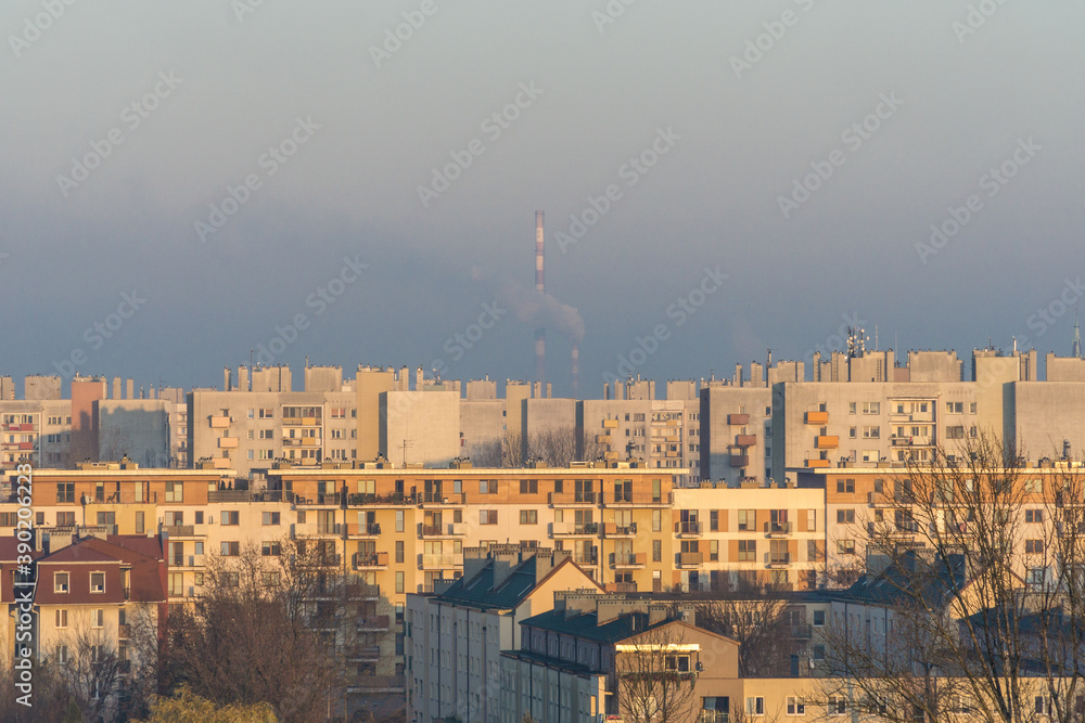 Air pollution visible against chimney and housing estate in Cracow