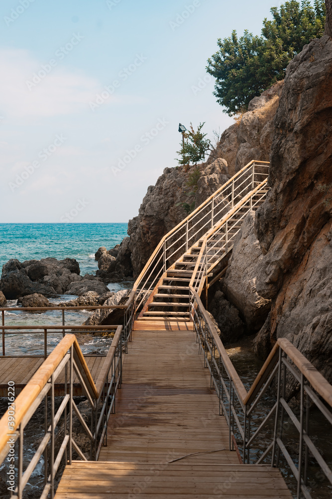 Obraz premium Wood stairs on a mountain road against the background of the sea and mountains