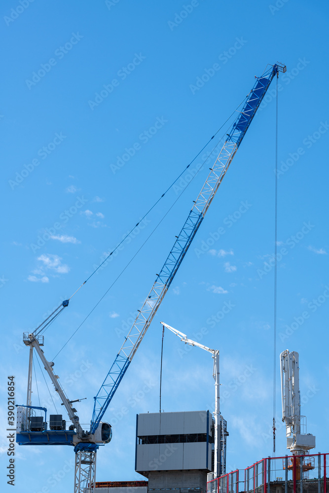 large construction cranes on site against a brilliant blue sky large construction cranes on site against a brilliant blue sky