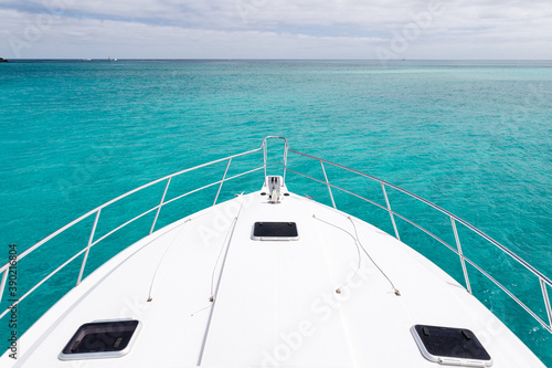 The bow of a luxury yacht sitting in clean clear turquoise ocean waters off the coast of Perth