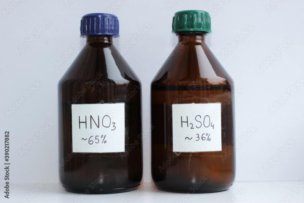 Two dark glass bottles of dilute acids, 65 percent nitric acid and