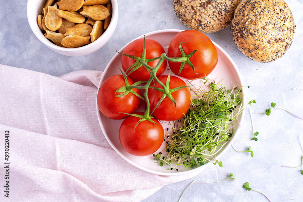 microgreens with tomatoes on a white plate and white plate with cookies and cereal buns microgreens with tomatoes on a white plate and white plate with cookies and cereal buns