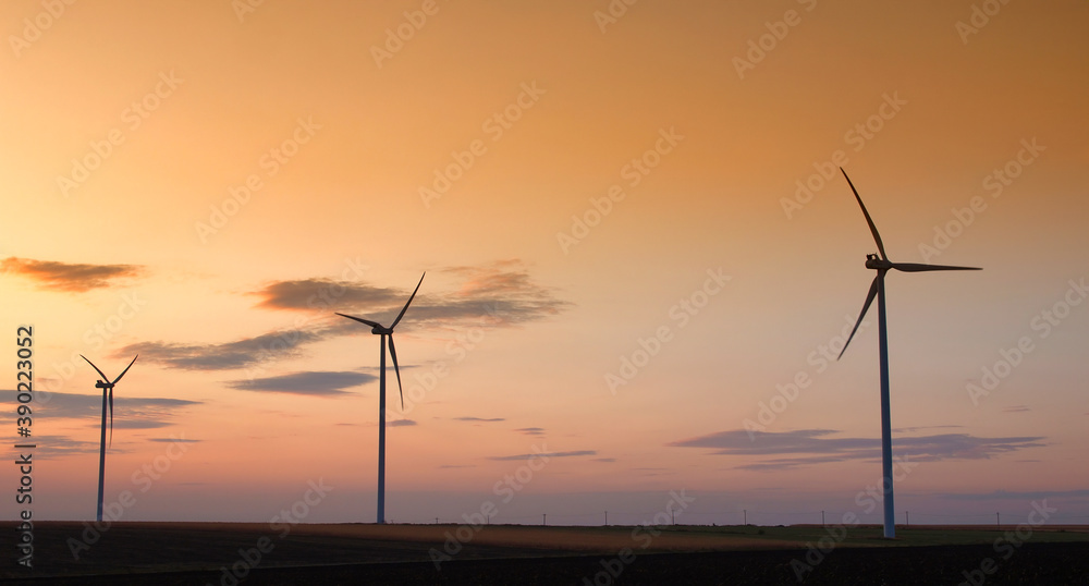 Wind turbine silhouette on colorful sunset landscape 