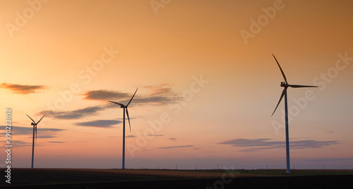 Wind turbine silhouette on colorful sunset landscape 