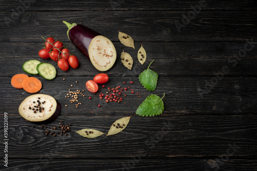 Healthy food. Vegetables on a dark wooden background. Top view. Copy space. Beautifully decorated still life of vegetables and leaves