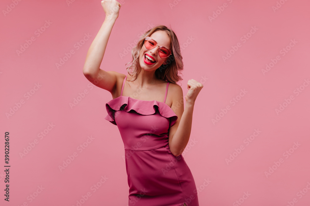 Blithesome european young woman in sunglasses dancing on rosy background. Inspired slim girl chilling in studio Blithesome european young woman in sunglasses dancing on rosy background. Inspired slim girl chilling in studio