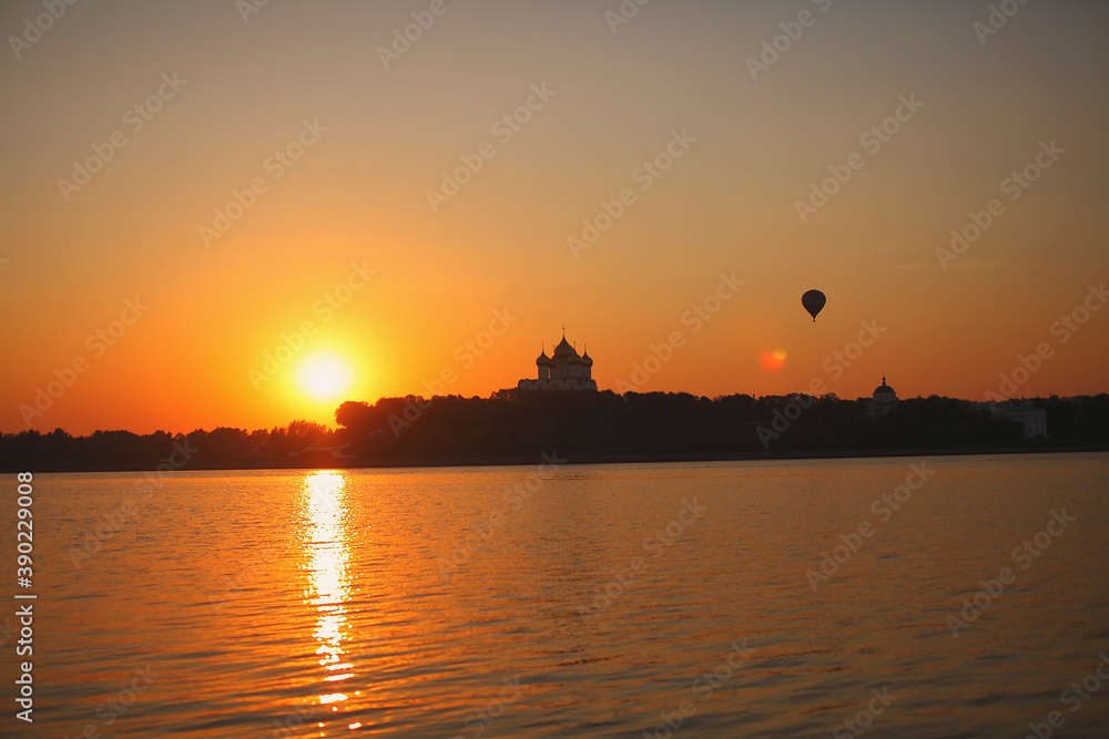 River at sunset with temple and hot air balloon