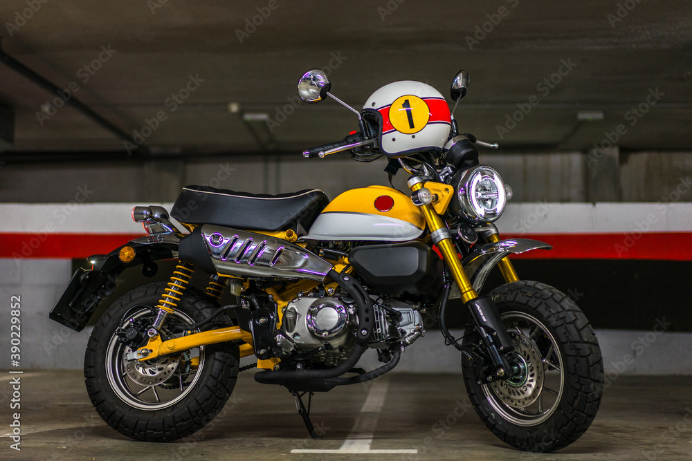 Fototapeta premium Disparo horizontal de una moto clásica color amarillo con un casco en el manillar